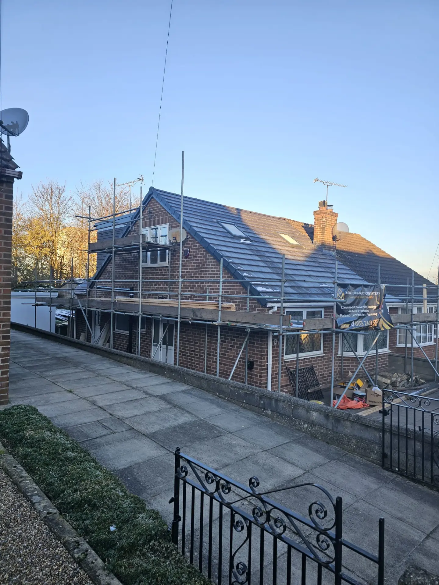 Loft conversion and re-roof in progress on a Leeds home with Y Elite Constructions scaffolding banner