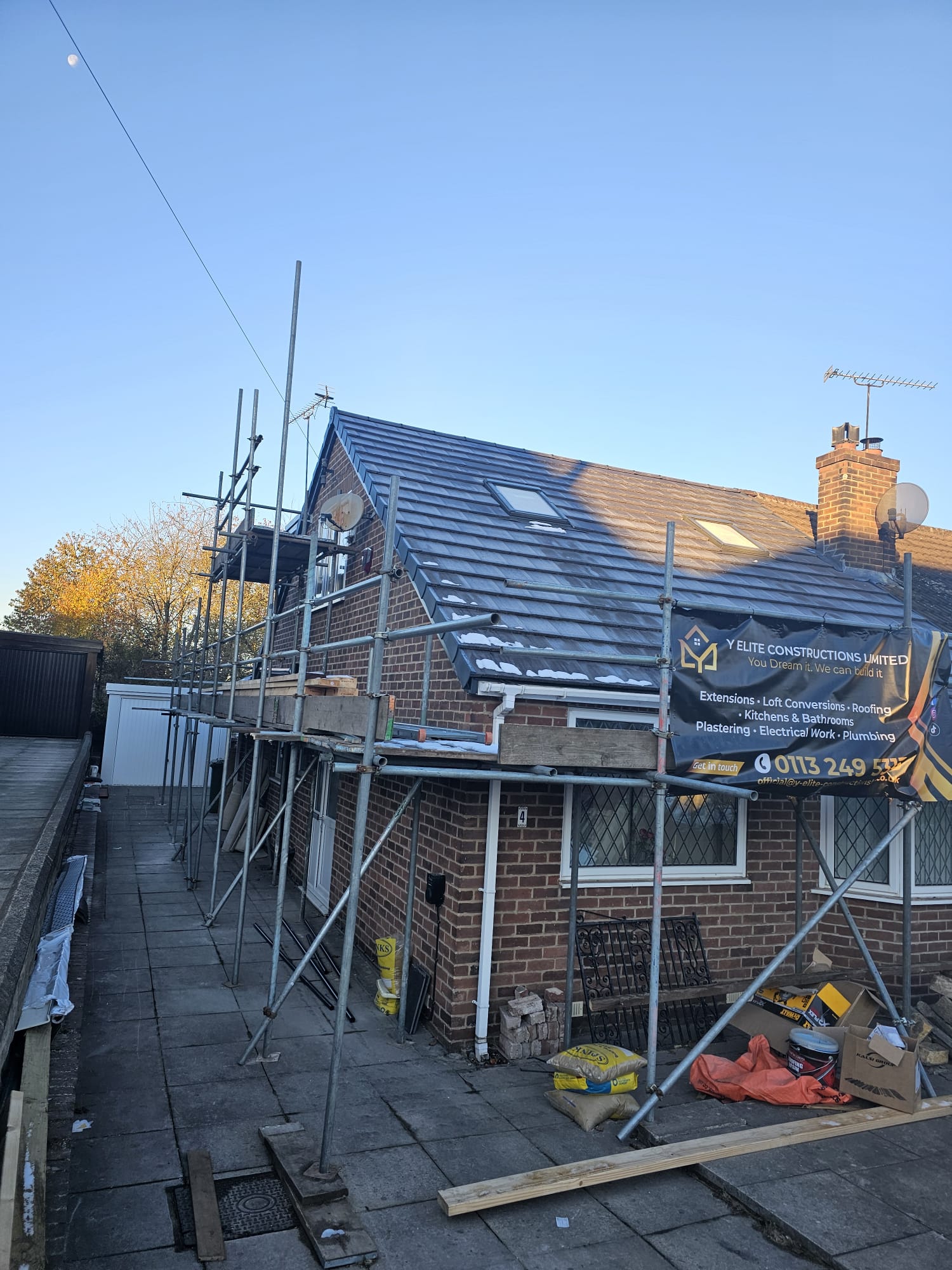 Leeds home exterior with scaffolding and business banner during a full renovation