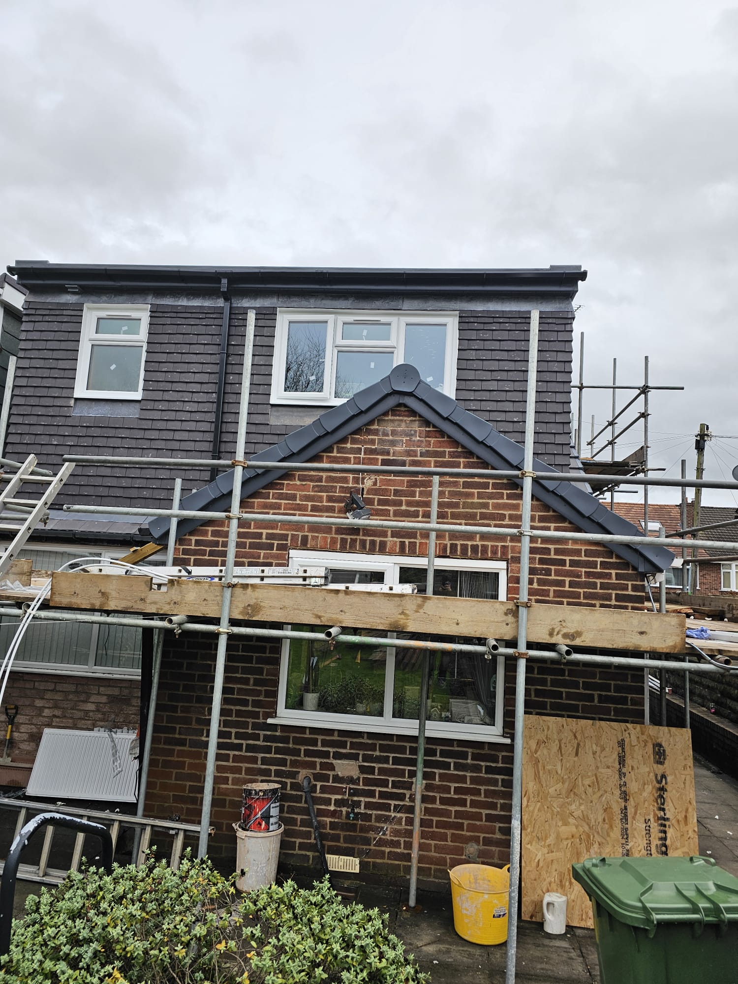 Rear view of Leeds home with scaffolding and new dark roof tiles being installed
