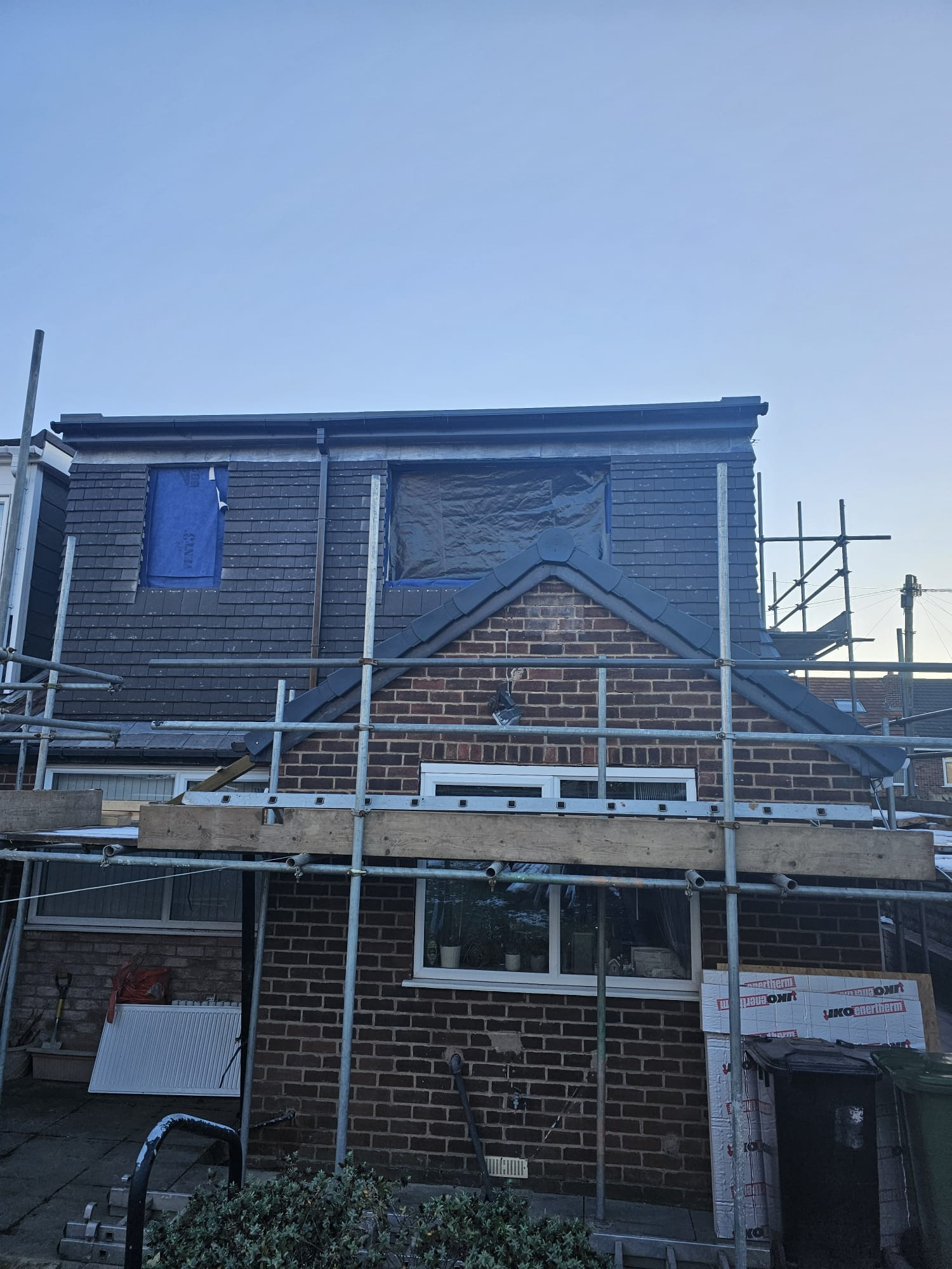 Dormer loft conversion under construction in Leeds with slate cladding and scaffolding