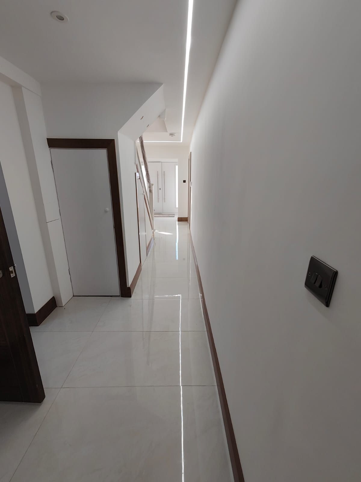 Freshly plastered hallway in Leeds with polished porcelain floor tiles and recessed LED lighting